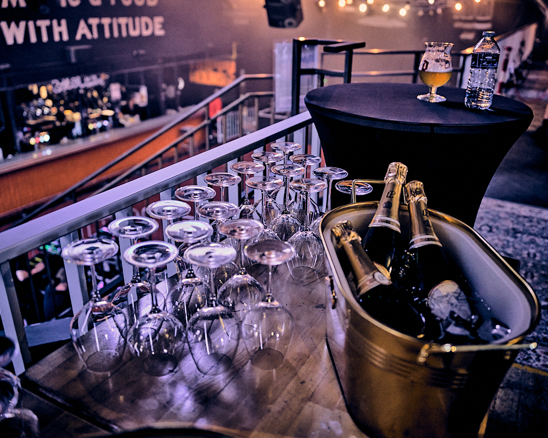 Espace VIP avec table haute, verres et champagne